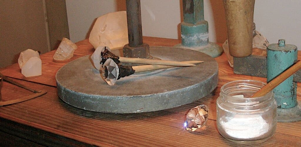 An old-fashioned faceting workstation with gemstones at various stages of polishing