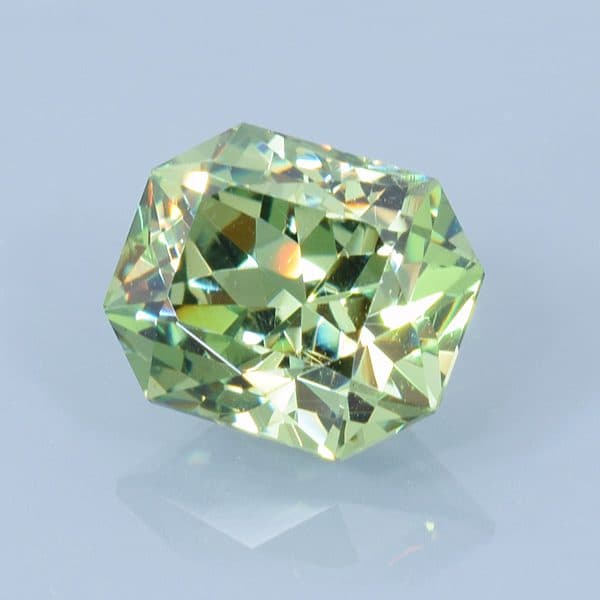 Finished version of Fancy Brilliant Emerald Cut Demantoid Garnet