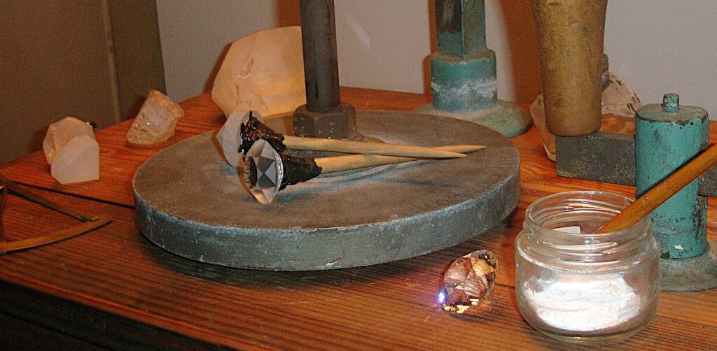 An old-fashioned faceting workstation with gemstones at various stages of polishing