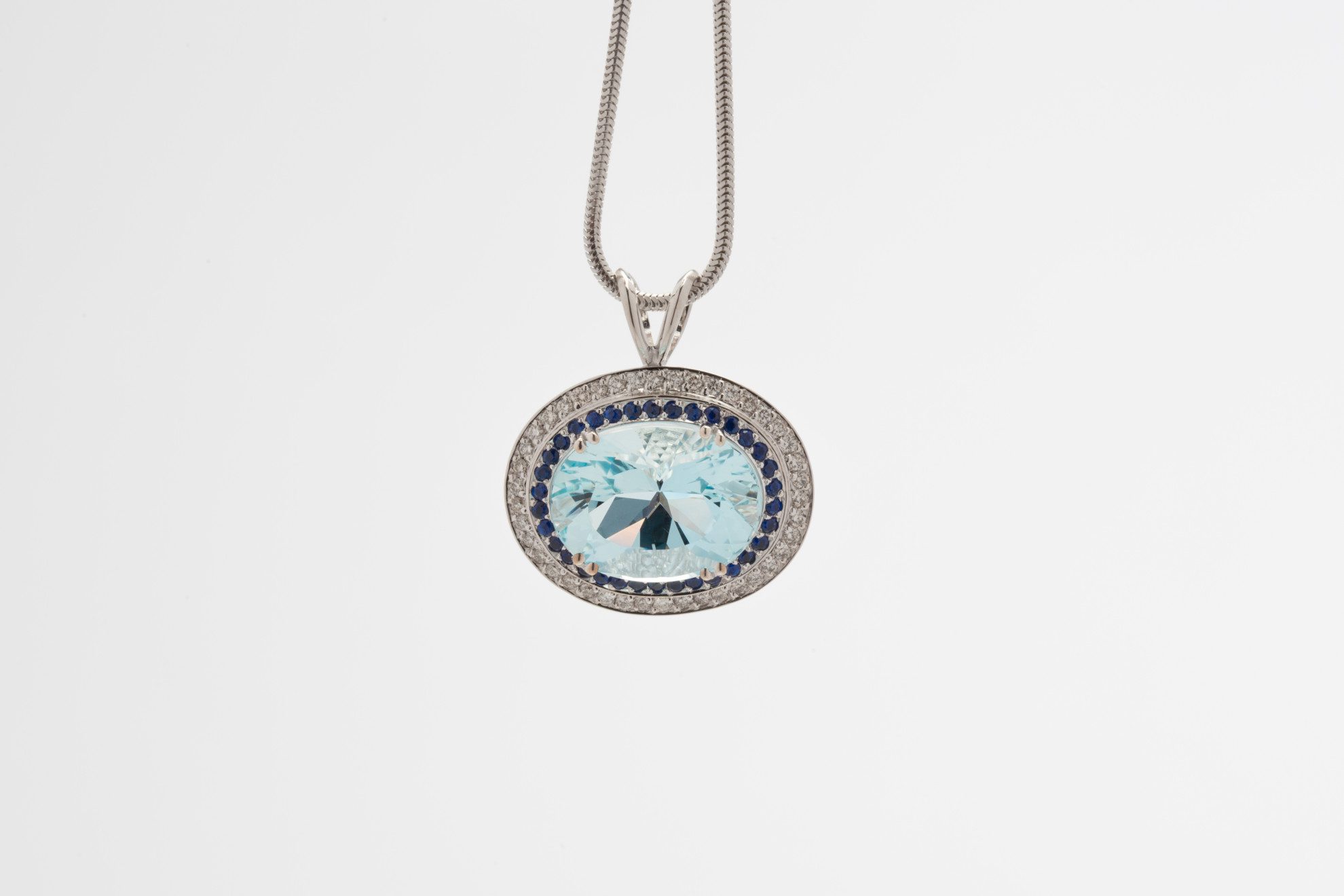 Re-Cut Aquamarine set into a pendant with sapphires and diamond melee