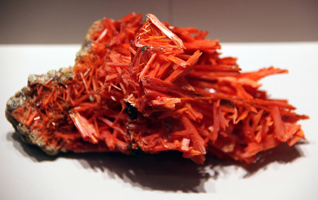 Beautiful saffron-colored crocoite gemstones are brittle and rarely faceted or worn as jewelry. If subjected to a streak test, crocoite will leave an orange streak. “Crocoite - Smithsonian Museum of Natural History – 2012-05-17” by Tim Evanson is licensed under CC By-SA 2.0